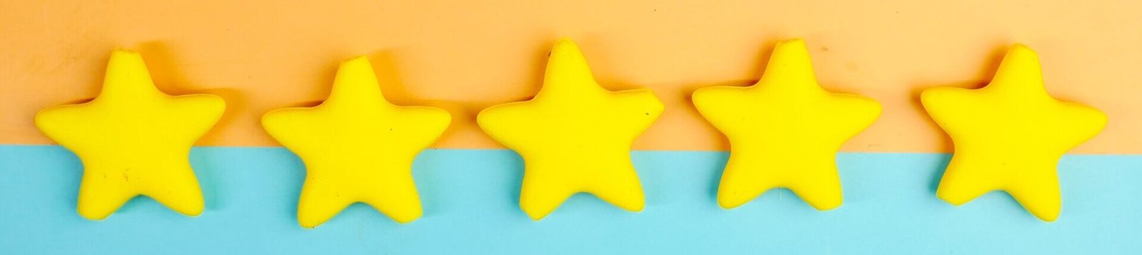 Bright yellow stars arranged on a vivid orange and blue background with copy space.